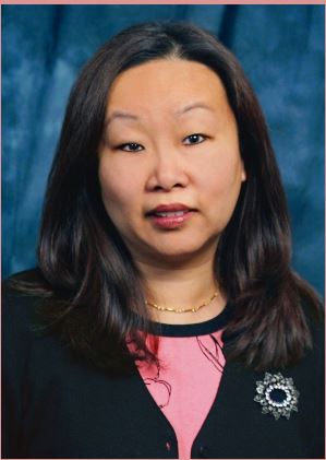 Woman with black hair, white skin, and pink tee shirt with black jacket.